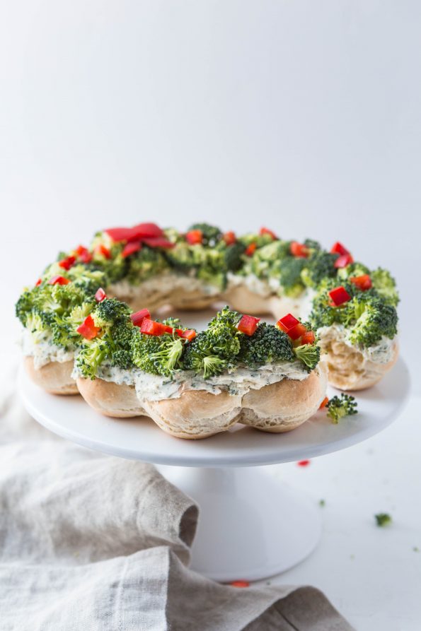 Bread rolls baked into a wreath shape and then smeared with ranch cream cheese and topped with broccoli and red pepper.