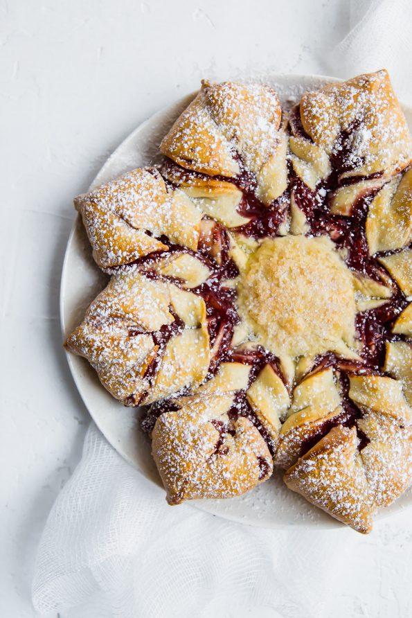 Overhead photograph of a raspberry filled pastry shaped like a star.