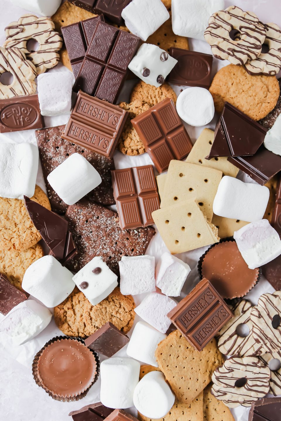 An overhead photo showing graham crackers, marshmlallows, and chocolate. The photo is messy with lots of different choices for s'mores fixings. 