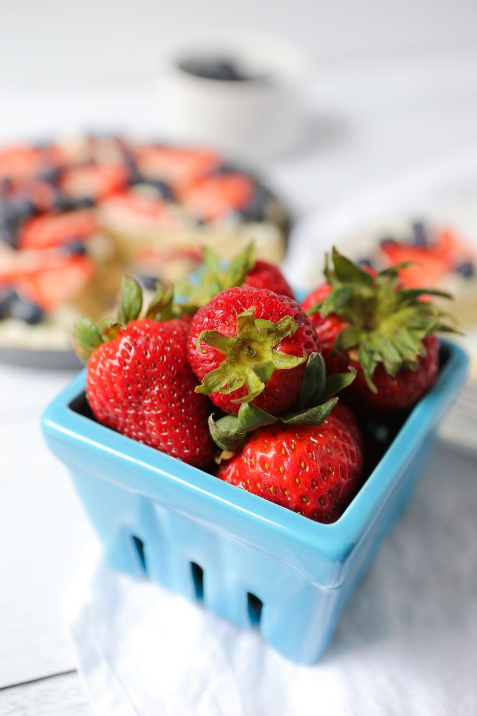 Beautiful photo of fresh ripe red strawberries in a blue ceramic berry container. 